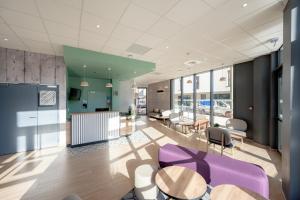 土伦B&B HOTEL Toulon Centre Gare的一个带紫色椅子和桌子的办公室大堂