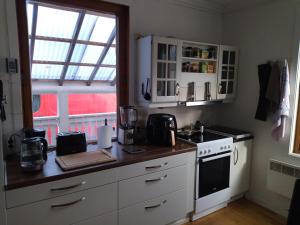 利勒斯特罗姆Nedre Kjellerstuvei, Oslo House Second floor的厨房配有白色橱柜、炉灶和窗户。