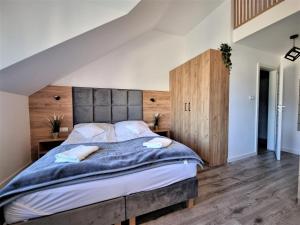 加茨比亚格拉Willa Sky的一间卧室配有一张大床和木制床头板