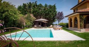 昂代Villa Enara的一个带椅子的庭院和房子的游泳池