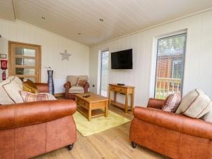 斯基普顿Robin Lodge的客厅配有两张沙发和一台电视机