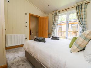 斯基普顿Robin Lodge的一间卧室设有一张大床和一个窗户。