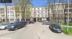 克拉科夫Apartament Osiedle Ogrodowe的一条在大楼前停放汽车的街道