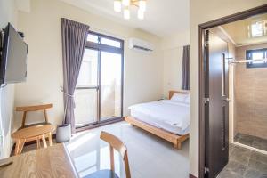 Hsing-wen別野城北的一间卧室配有一张床、一张桌子和一个窗户。