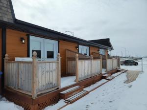 里穆斯基Motel Au Bord de l'Eau的雪地里设有木甲板的房子