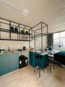 巴拉奈里奥-坎布里乌LOFT BC的一间厨房,配有蓝色橱柜和一张位于客房内的床