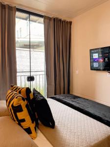 巴拉奈里奥-坎布里乌LOFT BC的卧室配有一张床铺,墙上配有电视