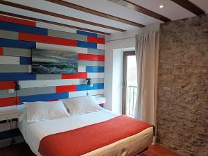圣维森特-德拉巴尔克拉角线酒店的一间卧室设有色彩缤纷的墙壁和床