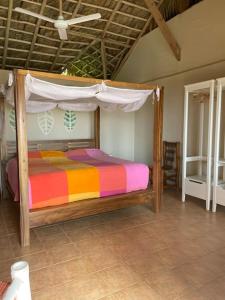拉斯加勒拉斯Villa Punta Coral的一间卧室配有一张木床和天篷