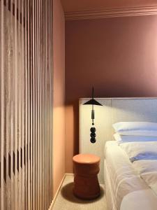 柏林ADELANTE Boutique Hotel的一间卧室配有一张床和一盏灯旁边的凳子