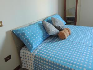 兰波雷基奥Il Chicco apartment的一张带蓝色波卡圆顶床单和枕头的床