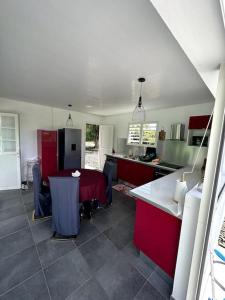 圣安娜VillaCalmflor的一间厨房,里面装有红色橱柜和一张桌子
