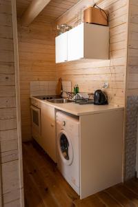 新瓦罗什ZlatAir Eco Chalet的厨房配有洗衣机和水槽