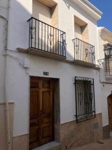 普里埃格·德·科尔多巴La Casa de Tente的白色的建筑,设有木门和阳台