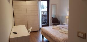 平佐洛加尼圣洛伦索酒店的一间卧室配有一张床、一张桌子和一个窗户。