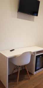 平佐洛加尼圣洛伦索酒店的一张带椅子的白色书桌和一台位于上面的电视