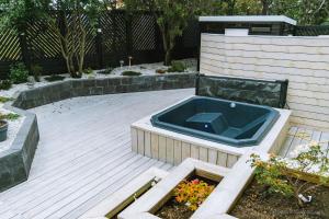 凯夫拉维克Smart Luxury - Private Gym, Hot Tub & Sauna的木甲板上的一个热水浴缸