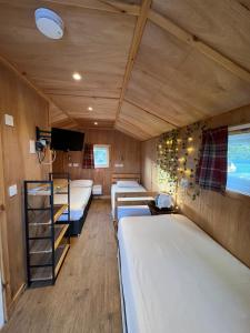 波特里Isle Of Skye Camping Pods的一间设有三张床和一台电视的房间
