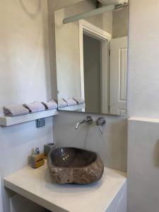 波多河丽Mimozas Apartment Porto Heli的一间带石制水槽和镜子的浴室