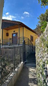 波西塔诺Casa la noce Positano的黄色的房子,有门和栅栏