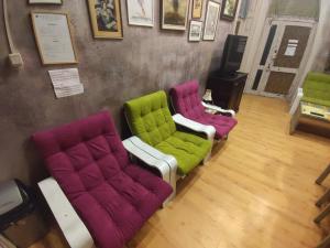 大特尔诺沃鲁斯特旅舍的三个不同的彩色椅子坐在房间里