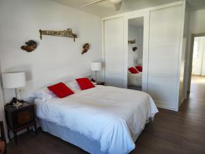 哈恩ENTREOLIVOS的卧室配有带红色枕头的大型白色床