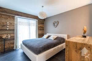 南达Appartement Rosalp, 200m des télécabines,的一间卧室设有一张床和木墙