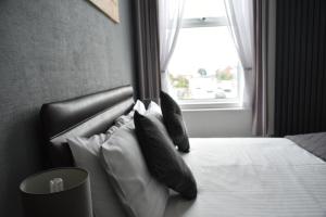 大雅茅斯汤顿之家酒店的卧室配有带枕头的床铺和窗户。
