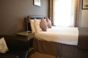大雅茅斯汤顿之家酒店的一间卧室配有带白色床单和粉红色枕头的床。