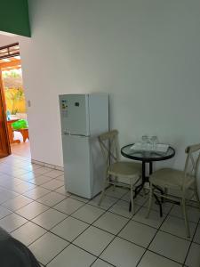 卡里略Cabinas El Colibri的厨房配有桌子和白色冰箱。