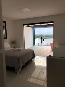 里约热内卢Suítes Luxo Marambaia- Epic House的一间卧室设有一张床和一个大型滑动玻璃门