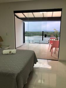 里约热内卢Suítes Luxo Marambaia- Epic House的卧室配有一张床,享有桌子的景色