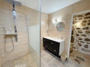 勒布伊Logis du Chandelier的一间带水槽和玻璃淋浴的浴室