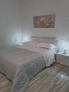 卢切拉Casa Rosy的白色卧室设有一张大床和木地板