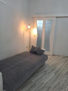 卢切拉Casa Rosy的卧室配有一张带墙上灯的床。