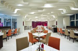 特里凡得琅Keys Select by Lemon Tree Hotels, Thiruvananthapuram的一间带桌椅和天花板的用餐室