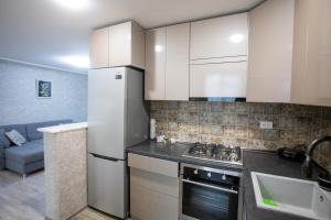 库塔伊西Ninia's Apartment的厨房配有白色橱柜和冰箱。
