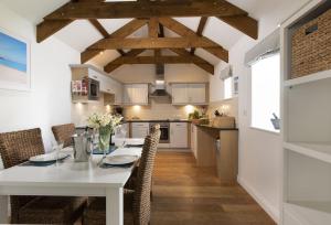卡比斯贝Lavender Cottage - Gonwin Manor的厨房以及带白色桌椅的用餐室。