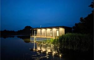 克鲁克兰基Pet Friendly Ship In Kruklanki With Lake View的一座晚上在水面上点亮的建筑