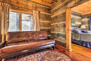 马吉谷The Cabin at Marys Place with Deck and Mtn Views!的一张皮沙发,位于带床的房间