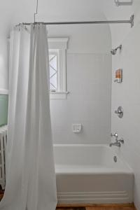 SpringfieldThe Hartness House的浴室内设有带浴帘的白色浴缸