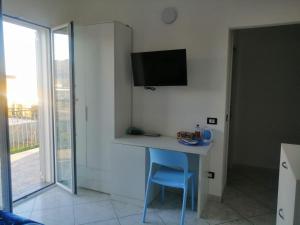 阿尔本加SOLELUNA的客房设有一张桌子,墙上配有电视。
