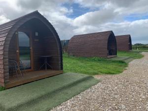 HullandPoplars Farm Site Glamping Pods的草屋,带桌子的几间小屋