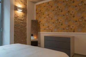 阿斯蒂Centro Storico Recinto dei Nobili 1 - private parking的一间卧室设有一张床和一个带壁炉的墙壁