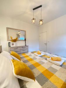 斯克拉丁Gold Apartments的一间卧室配有两张带黄色枕头的床