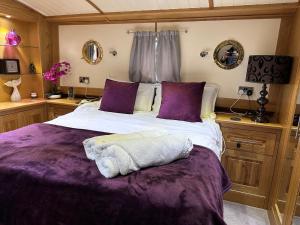 阿克斯桥Luxury boat - The Thistle Dream的一间卧室配有一张带紫色床单的大床