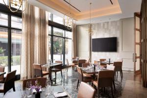 迈阿密Loews Coral Gables Hotel的餐厅设有桌椅和平面电视。