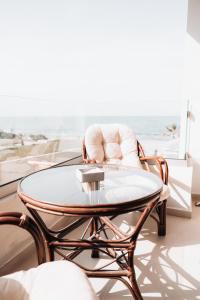 阿德里安诺斯坎波斯Indigo Seaside Experience的客厅配有咖啡桌和椅子,享有海景