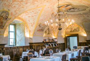 索普隆Sopron Monastery Hotel的一间带桌椅和吊灯的用餐室