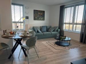 格丁尼亚Modern Vero Apartments Górskiego的客厅配有绿色沙发和桌子